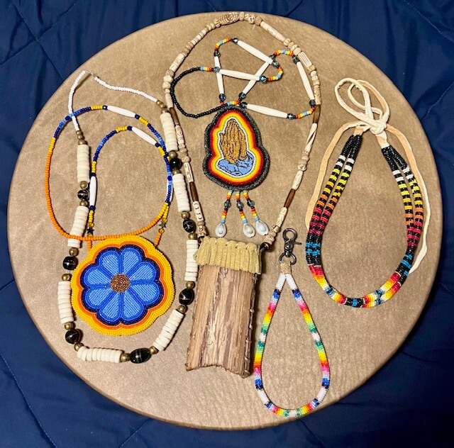 Various designs of native beadwork jewelry laid out on circular backdrop.