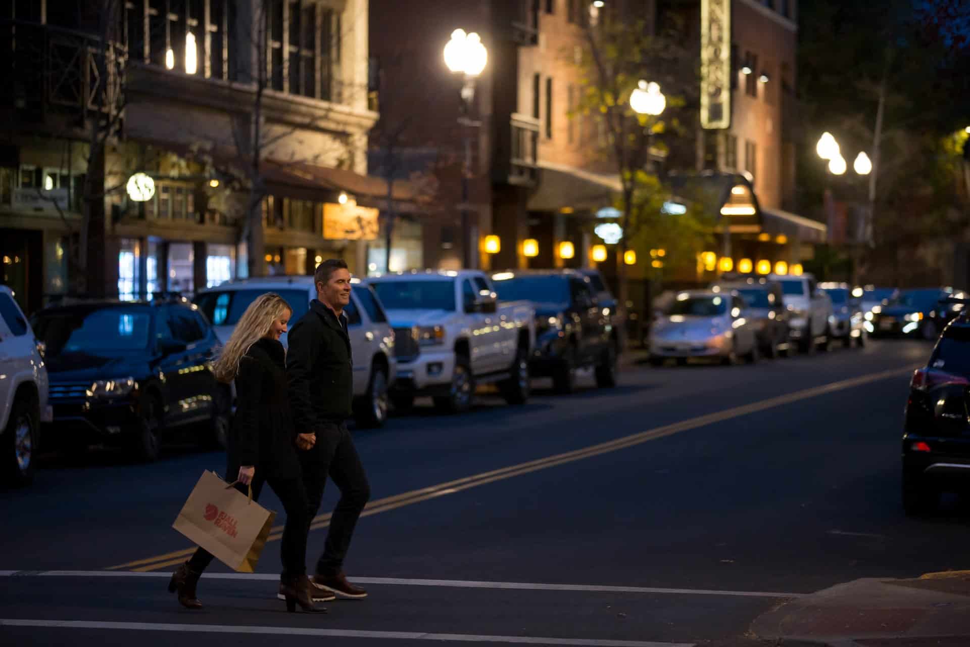 a couple walking down the street carrying a shopping bag a couple walking down the street carrying a shopping bag
