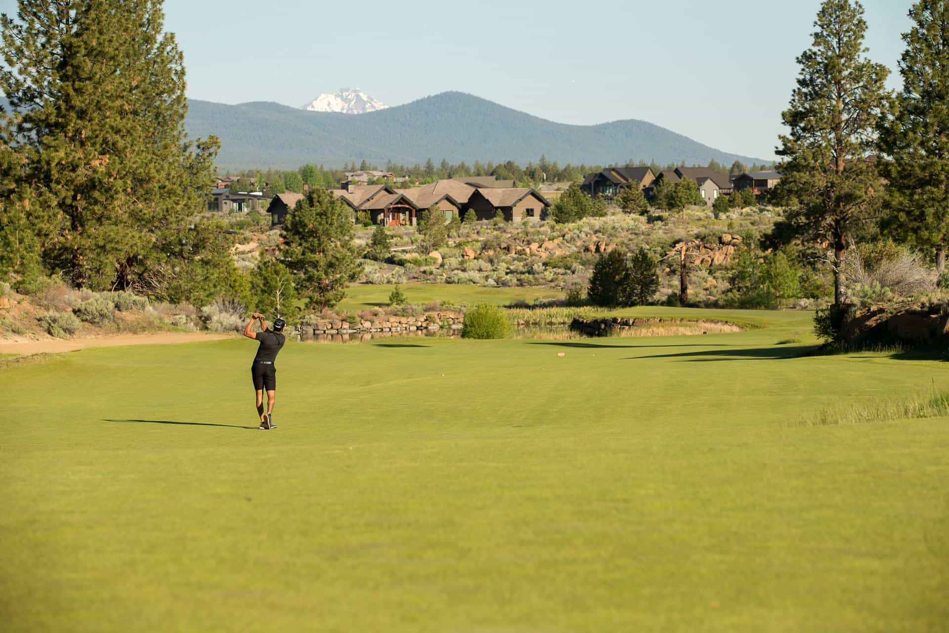 A golfer hits a golf ball on a green at Tetherow Resort. A golfer hits a golf ball on a green at Tetherow Resort.